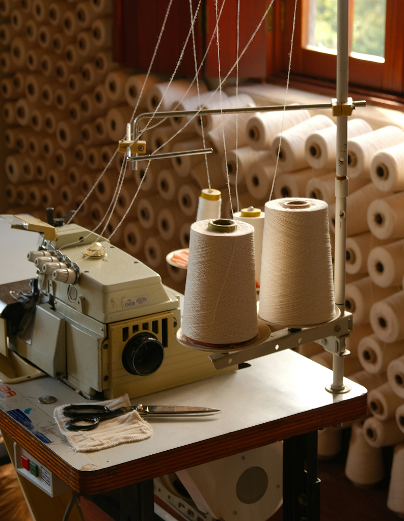Textile manufacturing workshop with sewing machine and fabric rolls